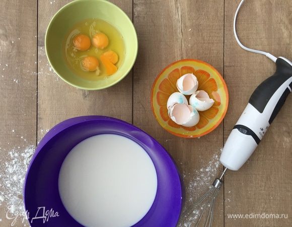 В большой миске на низкой скорости венчиком блендера взбиваем молоко «Домик в деревне» и яйца.
