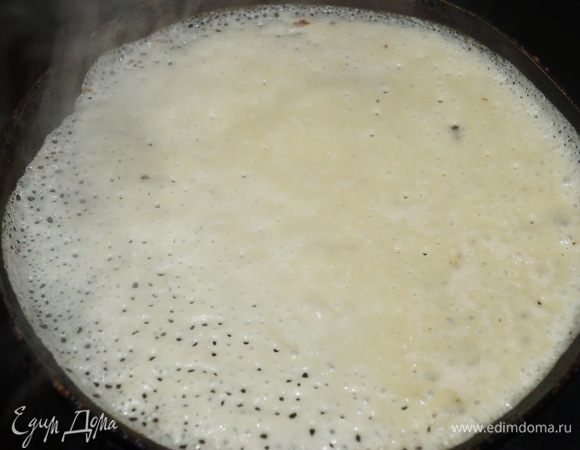 Блинную сковороду смазываем растительным маслом и раскаливаем на плите. Вливаем 100 мл теста (1 половник) и распределяем по всей поверхности.