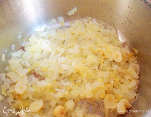 В кастрюле с толстым дном хорошо разогреть растительное масло. Выложить мелко нарезанный лук, чеснок, жарить около 5 минут до прозрачности и легкой золотистости. 