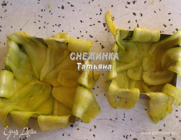 Теперь берем формы-заготовки, ставим на противень, смазанный оливковым маслом. Выкладываем дно и бока полосками цукини, достаточно плотно друг к другу. 