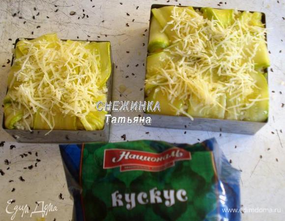 Сверху раскладываем кускус. Закрываем пироги верхней частью полосок цукини, присыпаем сыром. Ставим в разогретую до 180°С духовку на 10 — 15 минут до легкого зарумянивания.