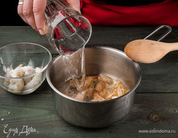 Сырые креветки чистим, головы и панцири с раздавленным чесноком складываем в емкость с толстым дном и обжариваем до красноты. Вливаем 1,5 литра воды и варим 20 минут. Бульон процеживаем и сохраняем.