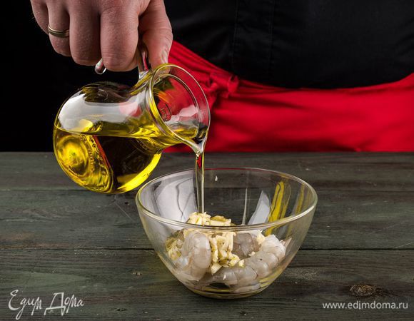 Чтобы замариновать креветки, мелко рубим чеснок, добавляем 2 ст. л. оливкового масла и перемешиваем с креветками. Оставляем мариноваться минут на 20.