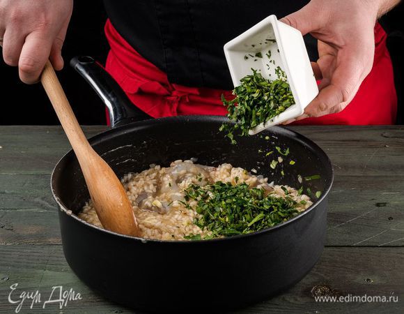 Мелко рубим зелень, добавляем ее вместе с креветками в ризотто.