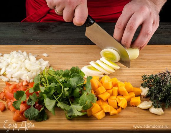 Духовку предварительно разогреть до 180°С. Тыкву почистить и нарезать кусочками по 3 см. Помидоры нарезать небольшими кубиками. Все остальные овощи тоже нарезать.
