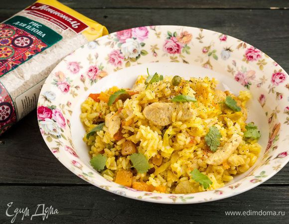 Достать из духовки и разрыхлить рис. Снова закрыть крышкой и оставить на 3 — 5 минут. Кинзу или петрушку мелко порубить. Готовый рис поперчить, посыпать нарубленной зеленью и подавать.
