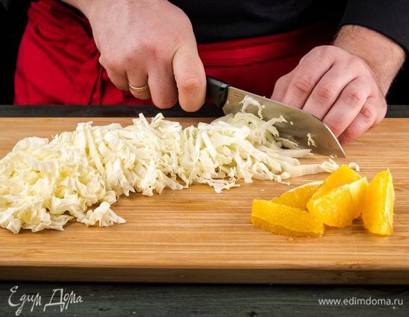 Апельсины очистите и нарежьте ломтиками. Листья капусты промойте, обсушите и нарежьте мелко.