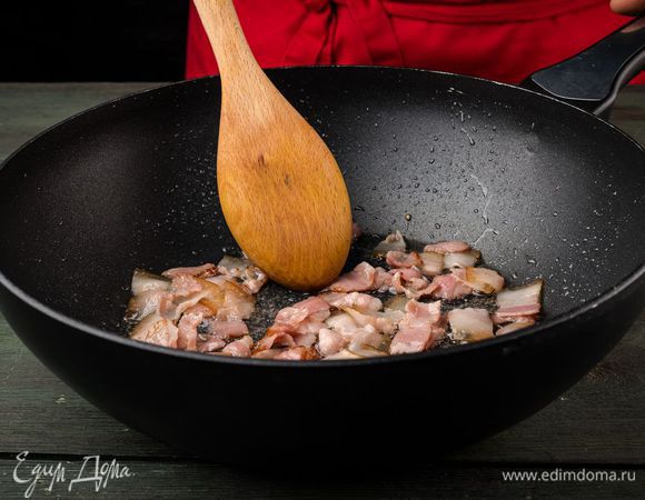 Разогреть в сковороде-вок 1 ч. ложку оливкового масла, обжарить бекон, затем выложить его на бумажное полотенце, чтобы удалить излишки жира.