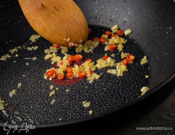 Сковороду-вок, где жарился бекон, протереть бумажным полотенцем, влить оставшееся оливковое масло и обжаривать имбирь и перец чили 1 — 2 минуты.