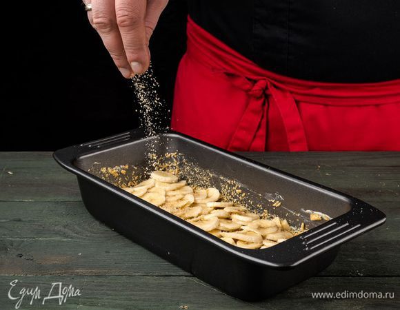 Форму смазать растительным маслом, присыпать крошкой из печенья, разложить кусочки банана, посыпать 2 ч. ложками сахара.