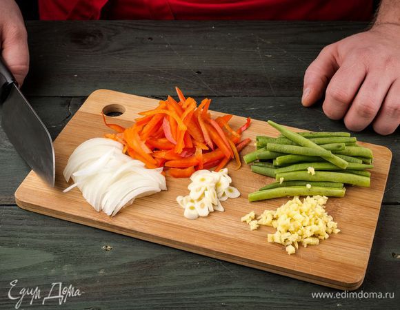 Нарезать лук, чеснок и имбирь тонкими кружочками. Болгарский перец нарезать полосками, фасоль разморозить и промыть.