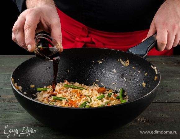 В вок добавляем соевый соус, немного обжариваем овощи в соусе и добавляем рис с паприкой.