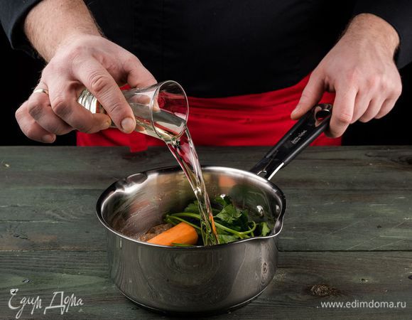 К панцирям креветок добавить нарезанную морковь, лук, веточки петрушки, влить вино, все перемешать и довести до кипения.