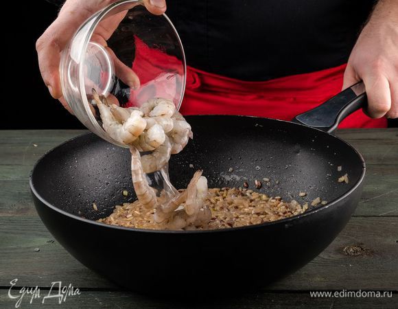 В готовый рис добавить очищенные креветки, перемешать и дать им прогреться.