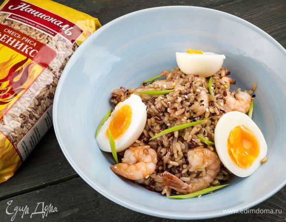 Выложить рис с креветками на блюдо, украсить отварными нарезанными яйцами и луком.

