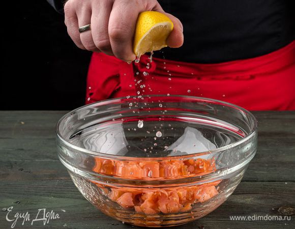 Рыбу нарезать кубиками размером 1 — 2 см, уложить в глубокую посуду, добавить сок половинки лимона, оливковое масло, по щепотке соли и перца. 