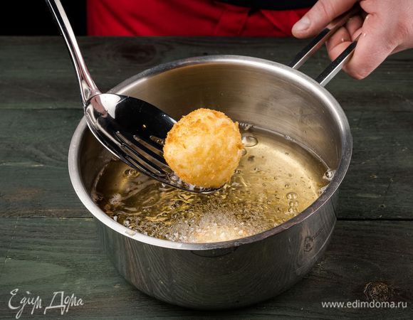 Разогреть в сотейнике оливковое масло и обжаривать шарики со всех сторон до появления золотистой корочки, а затем выкладывать на бумажное полотенце, чтобы убрать излишки жира.