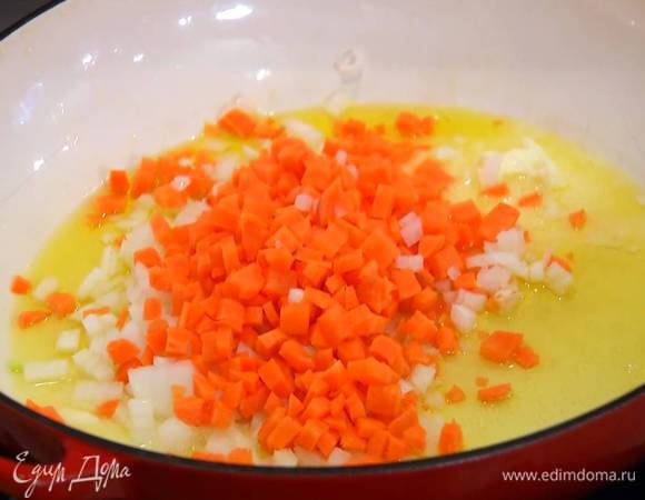 Разогреть в глубокой, тяжелой сковороде или сотейнике полторы ст. ложки оливкового масла и сливочное масло, обжарить морковь и нарезанный лук.