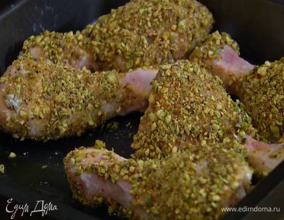 Куриные ножки вымыть, высушить, обвалять в муке и окунуть во взбитое яйцо, затем обвалять в измельченных фисташках и выложить в небольшой, глубокий противень, смазанный оливковым маслом.