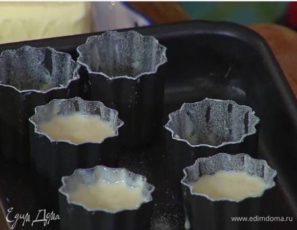 Формочки для канеле смазать оставшимся сливочным маслом, посыпать дно и боковые стенки оставшимся сахаром и разлить в них тесто.