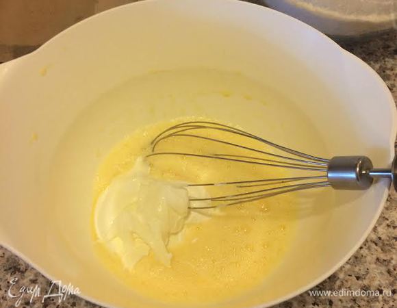 В другой миске слегка взбить яйца, затем добавить сметану и еще раз взбить.