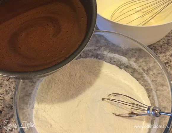 К муке добавить горячую шоколадную смесь и перемешать венчиком.