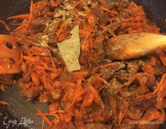 Морковь натереть на крупной терке, помидор очистить и нарезать. К мясу добавить томатную пасту, перемешать. Затем добавить морковь, помидор, специи, лавровый лист, 1/2 стакана воды, накрыть крышкой и тушить до готовности мяса.