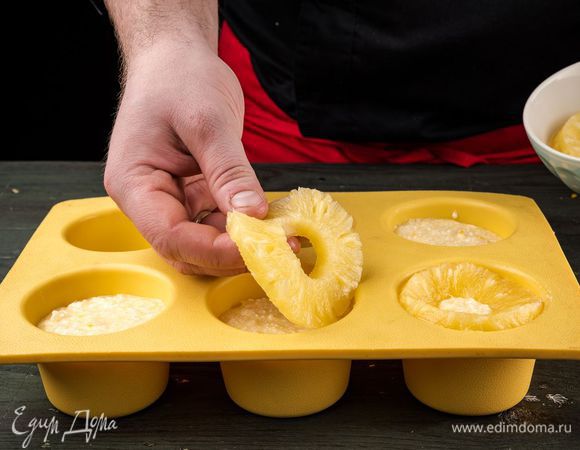 Смазать формочки маслом, наполнить их смесью, украсить кусочками ананаса. Выпекать в духовке 30 минут.