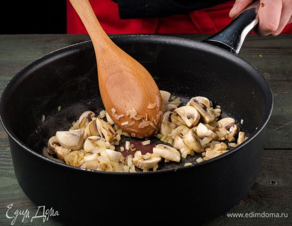 На растительном масле обжарить лук и нарезанные грибы.