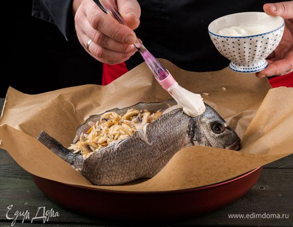 Нафаршировать рыбу. Сверху смазать сметаной.