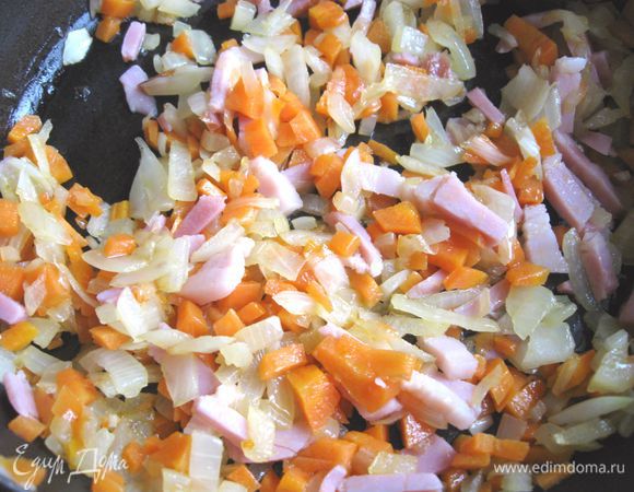 Приготовить соус. Морковь и лук почистить, мелко порезать. Поджарить овощи на оливковом масле на среднем огне на сковороде. Добавить бекон, порезанный полосками, дать немного времени, чтобы овощи и бекон объединились. В книге рекомендуется добавить еще кусочек стебля сельдерея.