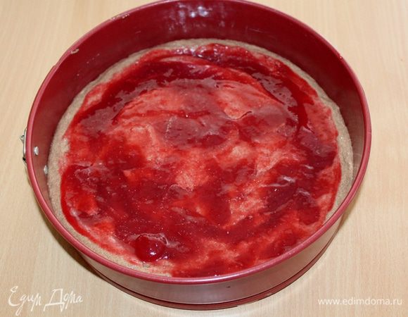 Половину теста равномерно выкладываем в форму. Сверху на тесто равномерно выливаем малиновый джем или варенье.