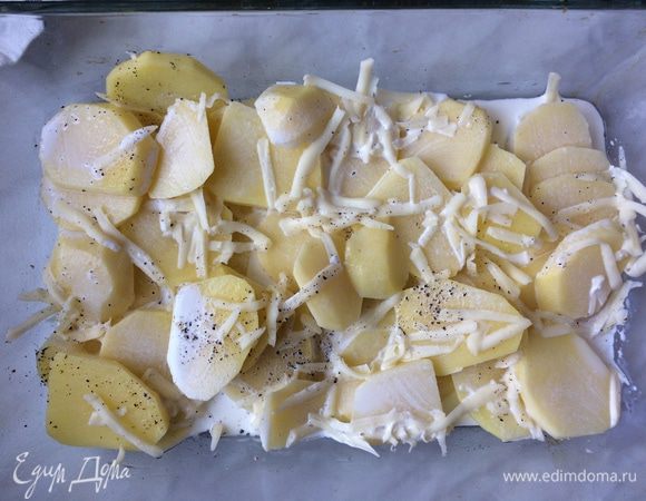 Форму для запекания смажьте оливковым маслом. Выложите картофель, посолите и поперчите. Добавьте 1/2 тертого сыра, залейте сливками и добавьте 1 ст. л. воды. Перемешайте и запекайте 25 минут. За 5 мин. до готовности посыпьте оставшимся сыром.