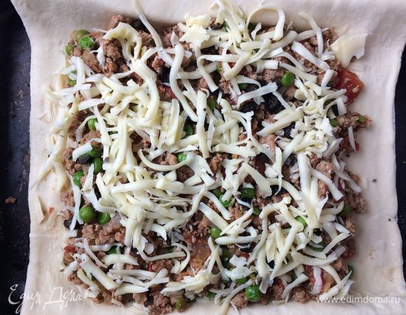 Форму для запекания смажьте растительным маслом. Перенесите тесто в форму, затем выложите сверху содержимое сковороды. Посыпьте рубленными оливками и моцареллой. Загните края теста на начинку. Отправьте в духовку на 20 минут. 