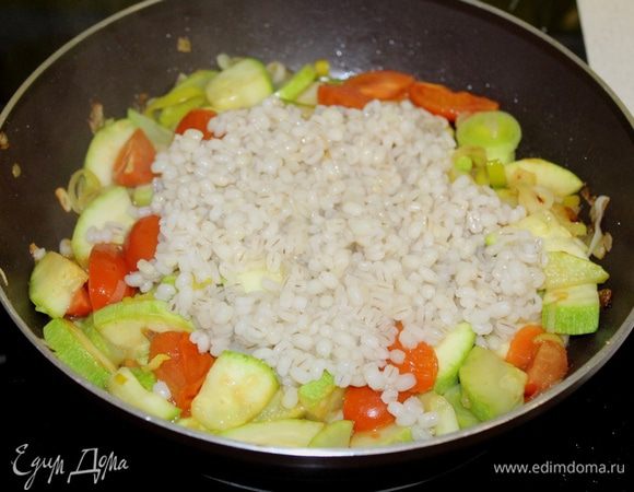 Добавить крупу к овощам, перемешать. Подавать салат теплым.