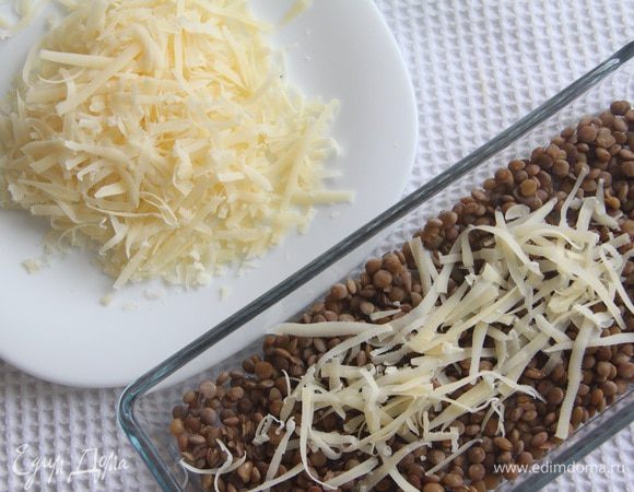 Натереть на крупной терке 50 г твердого сыра. Выложить на чечевицу.