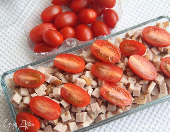 Помидоры черри разрезать на половинки и добавить в салат.