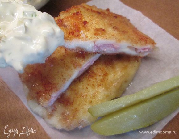 Из майонеза, молока,  горчицы и мелко нарезанного огурца и петрушки делаем соус. Подаем теплый сыр, полив соусом и украсив листиками петрушки.