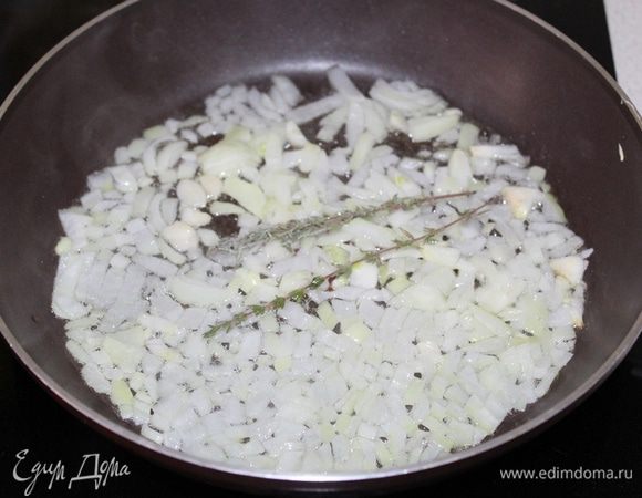 Луковицу и чеснок нарежьте. Разогрейте немного растительного масла и обжаривайте лук с чесноком на среднем огне.
Добавьте в сковороду пару веточек тимьяна.
