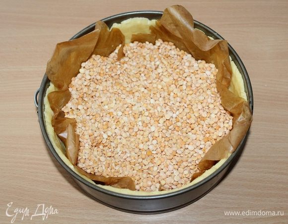 В разогретую до 180°С духовку отправить тесто, прижав его грузом. Выпекать 10–15 минут.