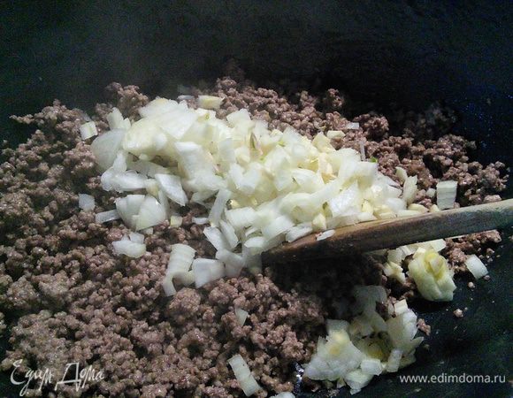 В кастрюле с толстым дном разогреть масло и обжарить фарш. Добавить лук и чеснок и обжарить вместе еще пару минут. 