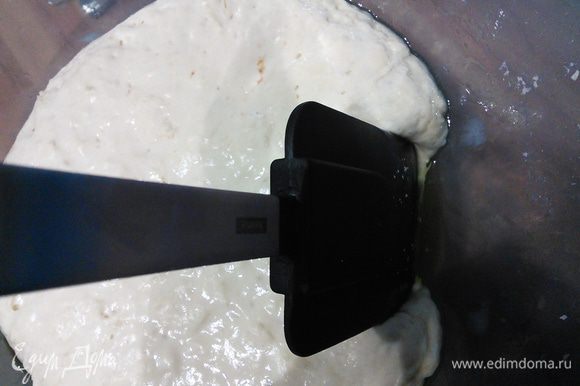 Теперь нужно тесто обмять, но следующим образом. Для этого нужно тонкой струйкой влить оливковое масло по краям чаши (2-3 ст. л.) и силиконовой лопаточкой отделить тесто от стенок.