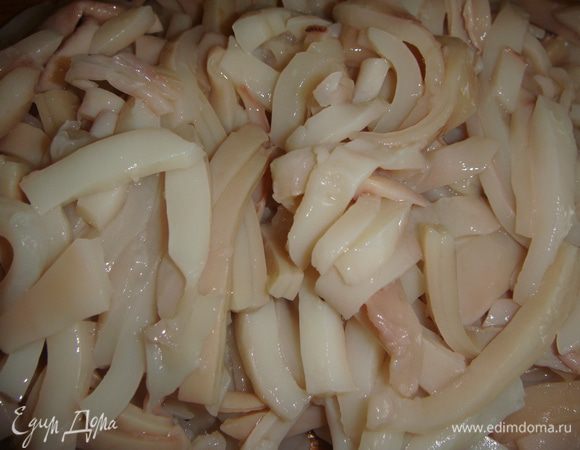 Кальмары помыть, обдать кипятком, снять кожицу и еще раз промыть. Нарезать тонкими полосками. 