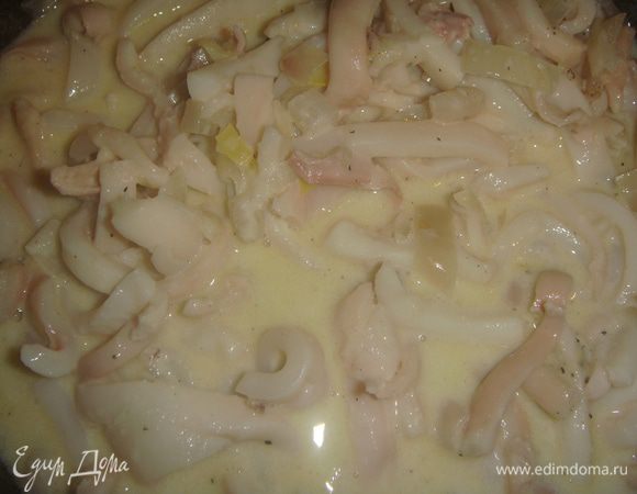 Влить сливки, посолить, поперчить и добавить мускатный орех. Накрыть сковороду крышкой и тушить кальмары 4 минуты.