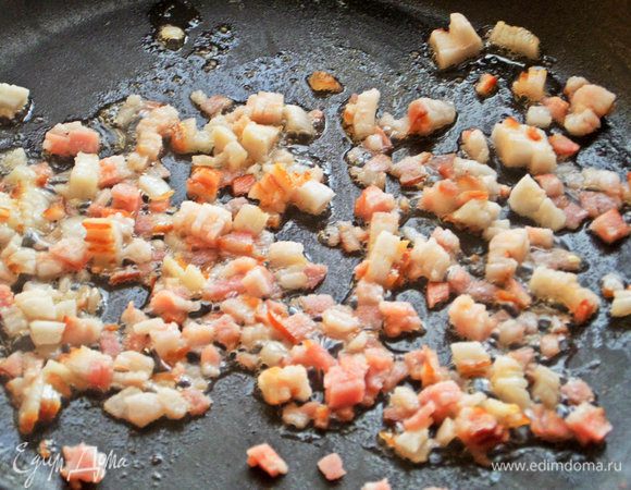 Нагреть в сковороде кубики бекона.