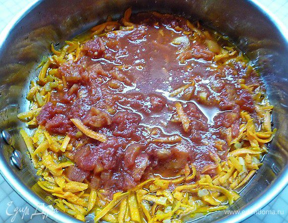 В сковороде разогреваем подсолнечное масло, зажариваем до золотистого цвета мелко нарезанный лук, добавляем натертую на терке морковь, мелко нарезанные помидоры и заливаем все томатом. Все перемешиваем и даем немного прокипеть.