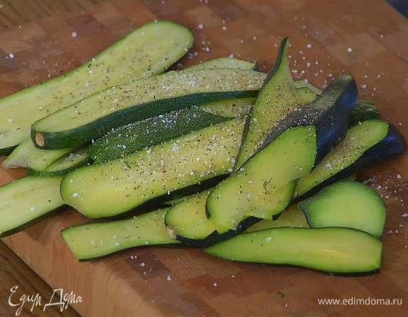 Цукини нарезать вдоль пластинами толщиной 2 мм, посолить, поперчить и сбрызнуть оливковым маслом.