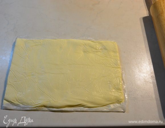 Тем временем положить слегка размягченное сливочное масло в пакет. Удобно и тесто, и масло сложить в пакет одного размера, позже вы поймете почему. Раскатать скалкой в прямоугольник. Убрать в холодильник вместе с тестом.