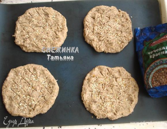 Делим тесто на 4 части, формируем круглые лепешки, кладем на противень, смазанный маслом, или силиконовый коврик. Делаем надрезы острым ножом и присыпаем кунжутным семенем. 