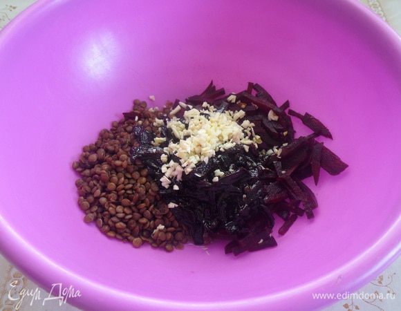 Выкладываем в чашку нарезанную свеклу, отваренную чечевицу, обжаренный чернослив и нарезанный чеснок.